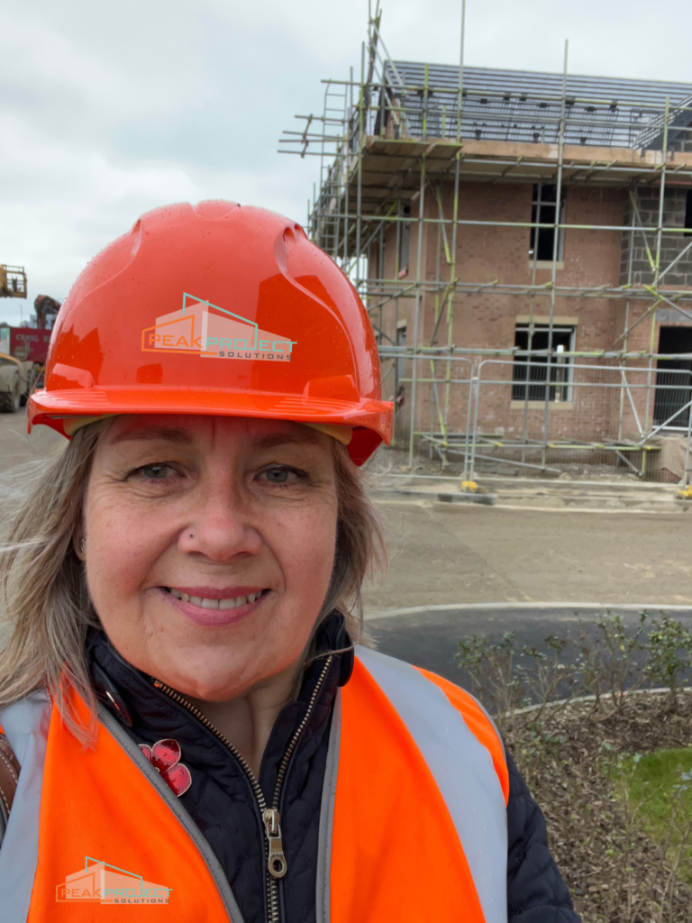Ruth in orange hard hat and hi vis jacket on a building site