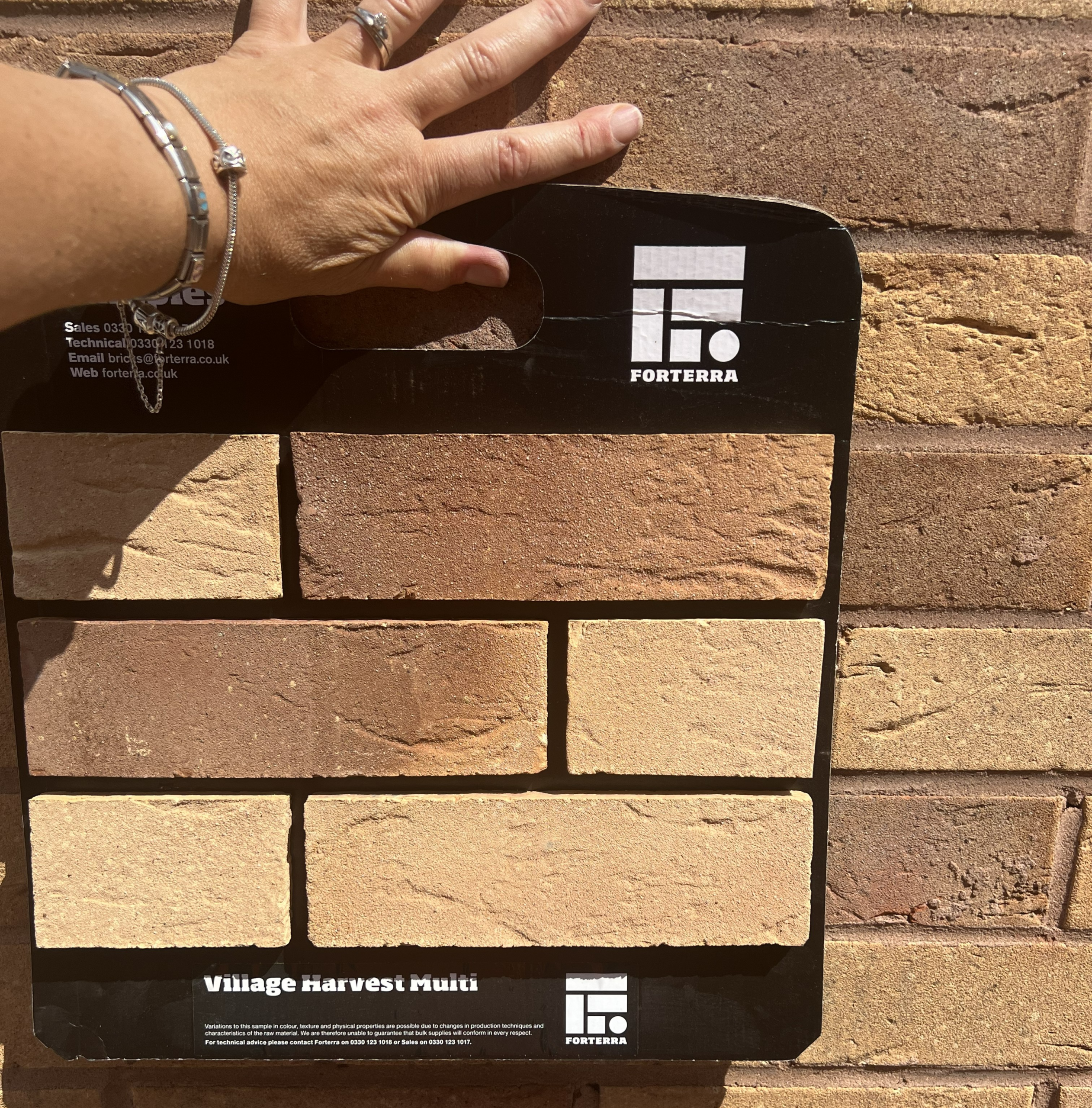 Brick Match - Forterra Village Harvest Multi Photo of a sample panel of buff bricks held against a wall of buff bricks